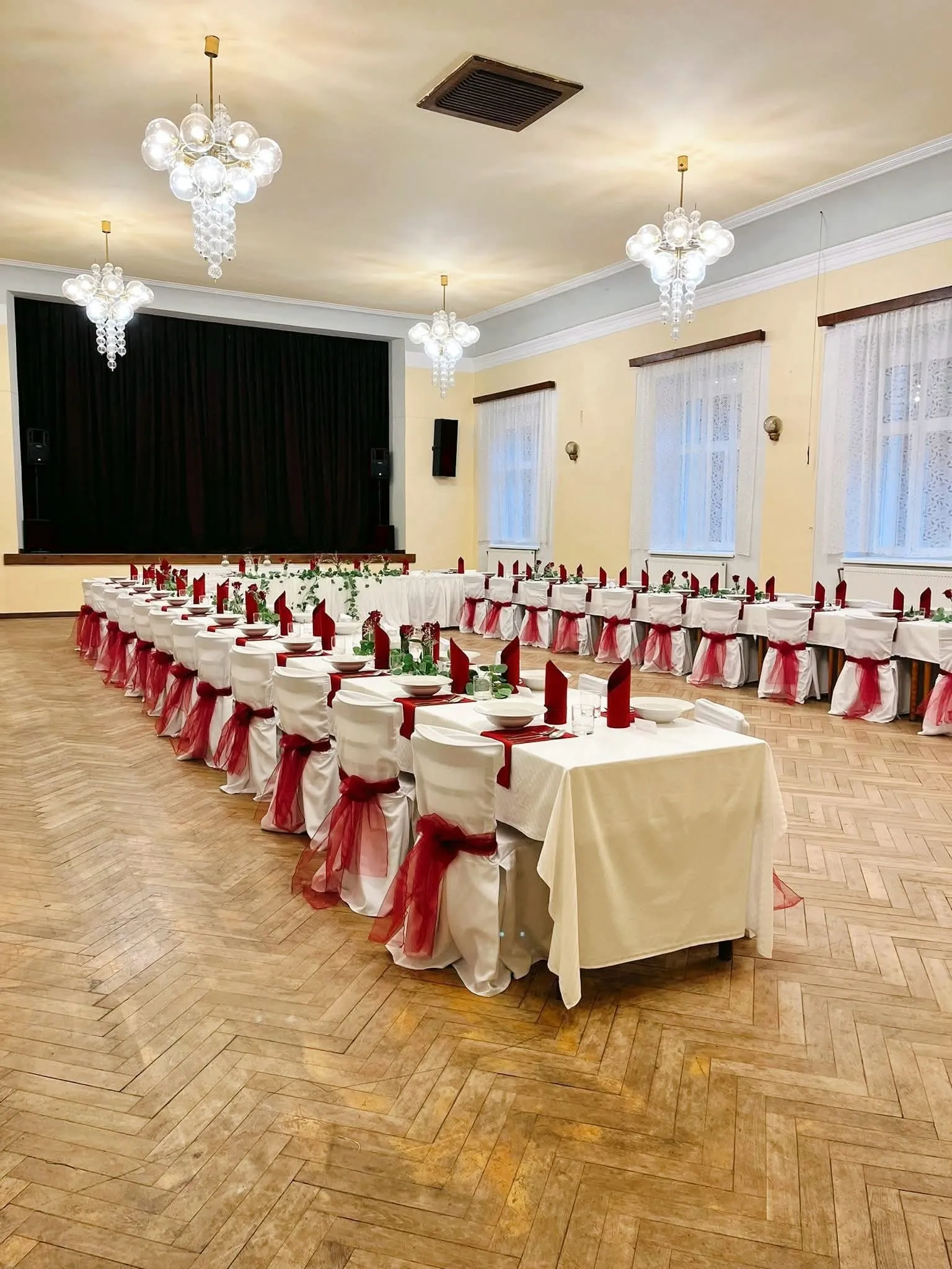 Velký sál Liďáku s křišťálovými lustry, nachystaný na svatební hostinu