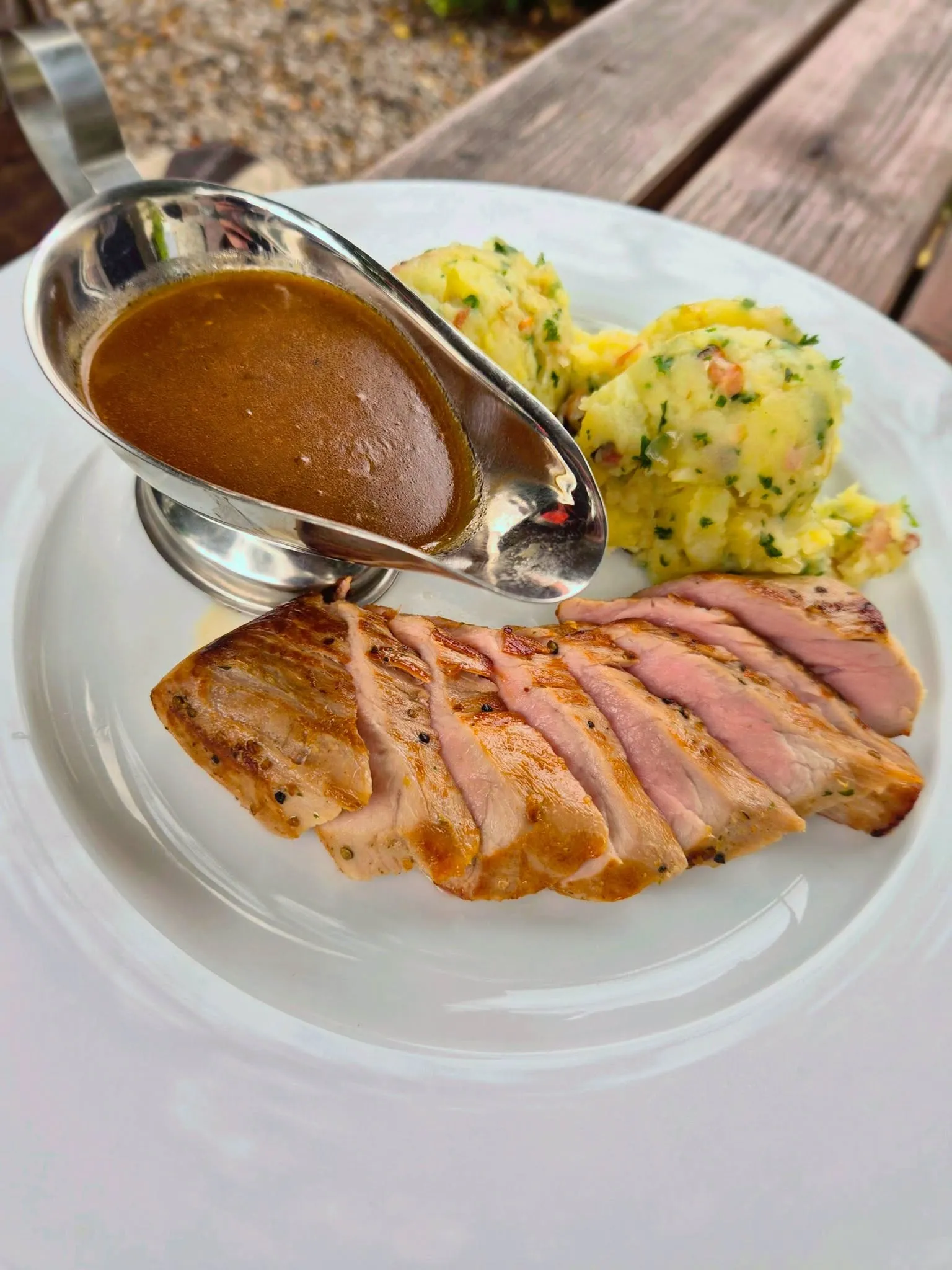 Nakrájený grilovaný steak s omáčkou a bramborami s petrželkou